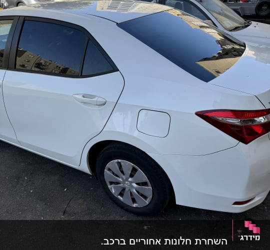 מכונית לבנה עם חלונות כהים בחניה